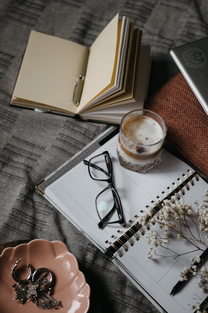 Mastering the First Impression: Your intriguing post title goes here A warm and cozy home workspace featuring a notebook, coffee, and reading glasses.
